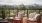 a deck with chairs and a table with a view of trees and mountains