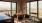 a room with a table and chairs and a large window with a view of the city